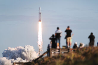 People watch as the SpaceX Falcon Heavy rocket lifts off from launch pad 39A at NASA’s Kennedy Space Center on April 11, 2019 in Titusville, Florida. The rocket is carrying a communications satellite built by Lockheed Martin into orbit. Credit: Joe Raedle/Getty Images